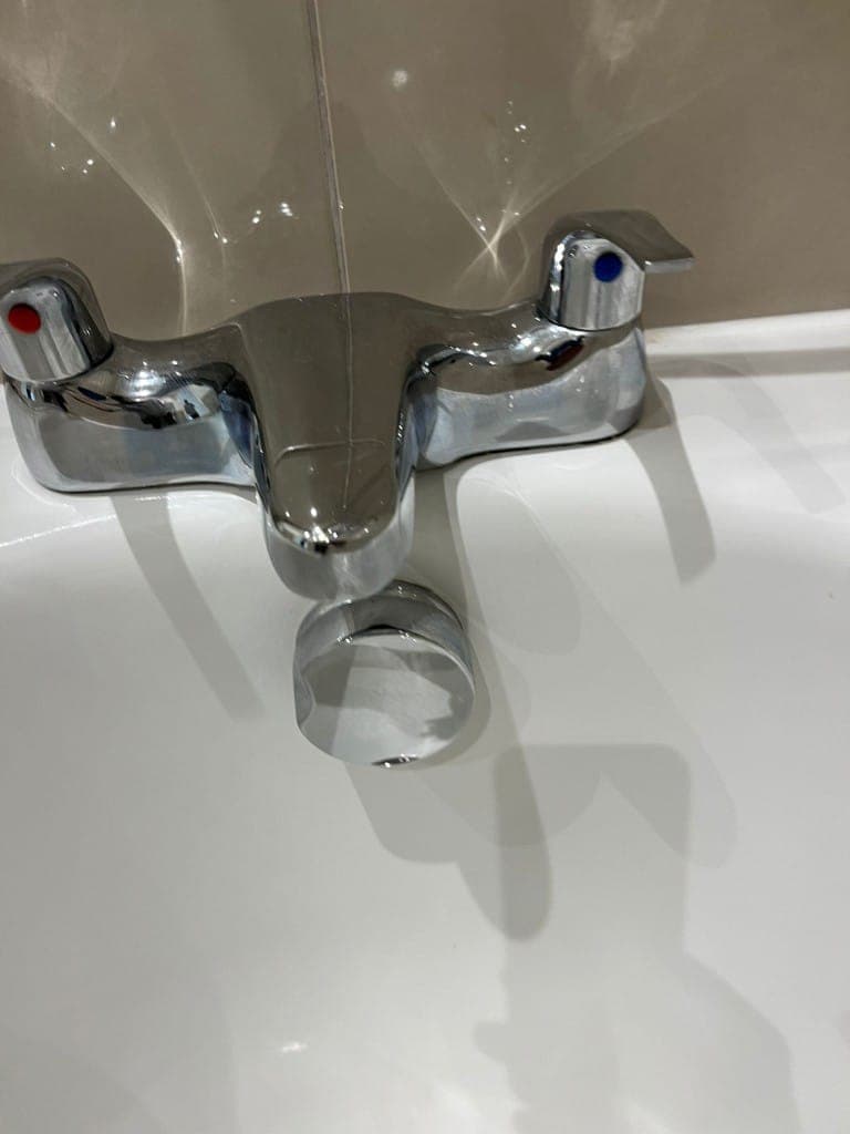 Bathroom tap after cleaning: chrome basin mixer descaled and polished to a bright mirror shine