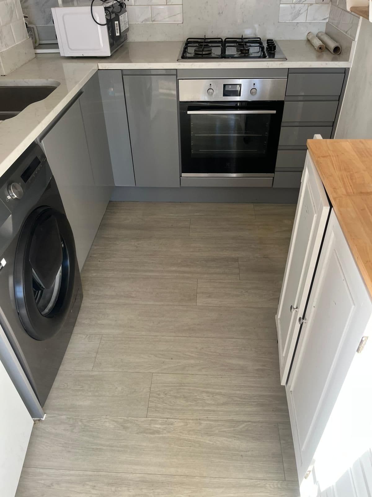 The same grey kitchen cleared and cleaned to checkout standard with a spotless floor