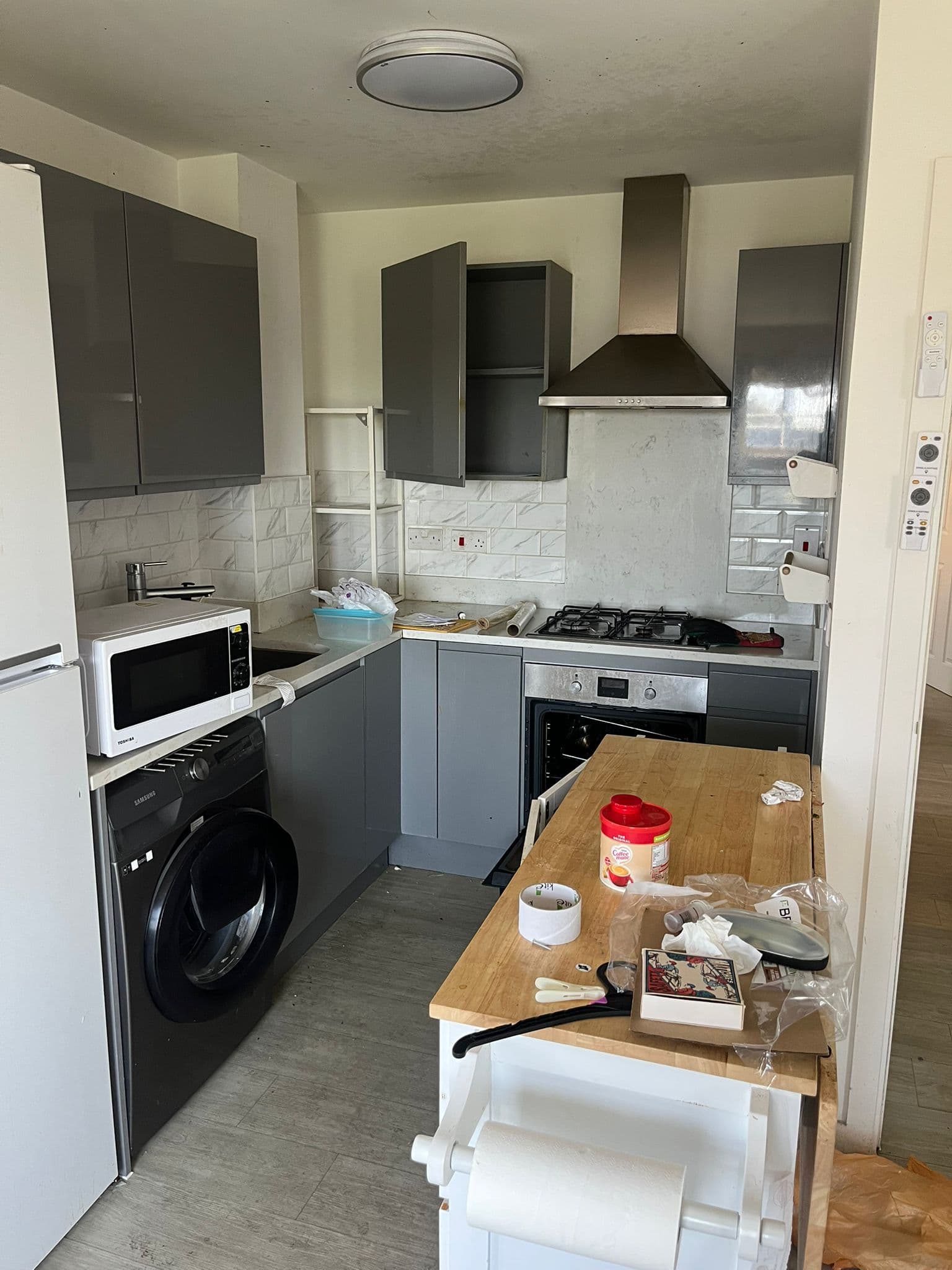 Cluttered grey kitchen with items left on the worktops before an end of tenancy clean