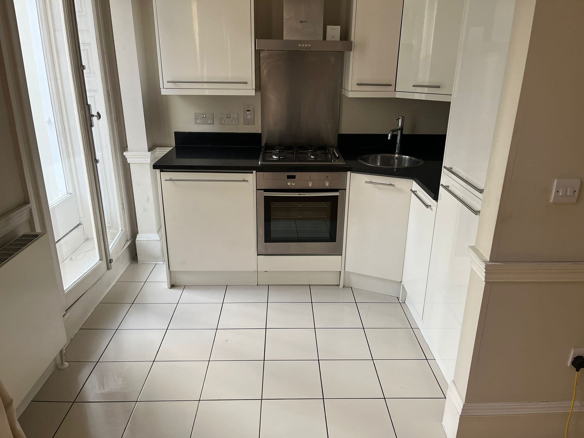 Clean white tiled kitchen floor with brightened grout after cleaning