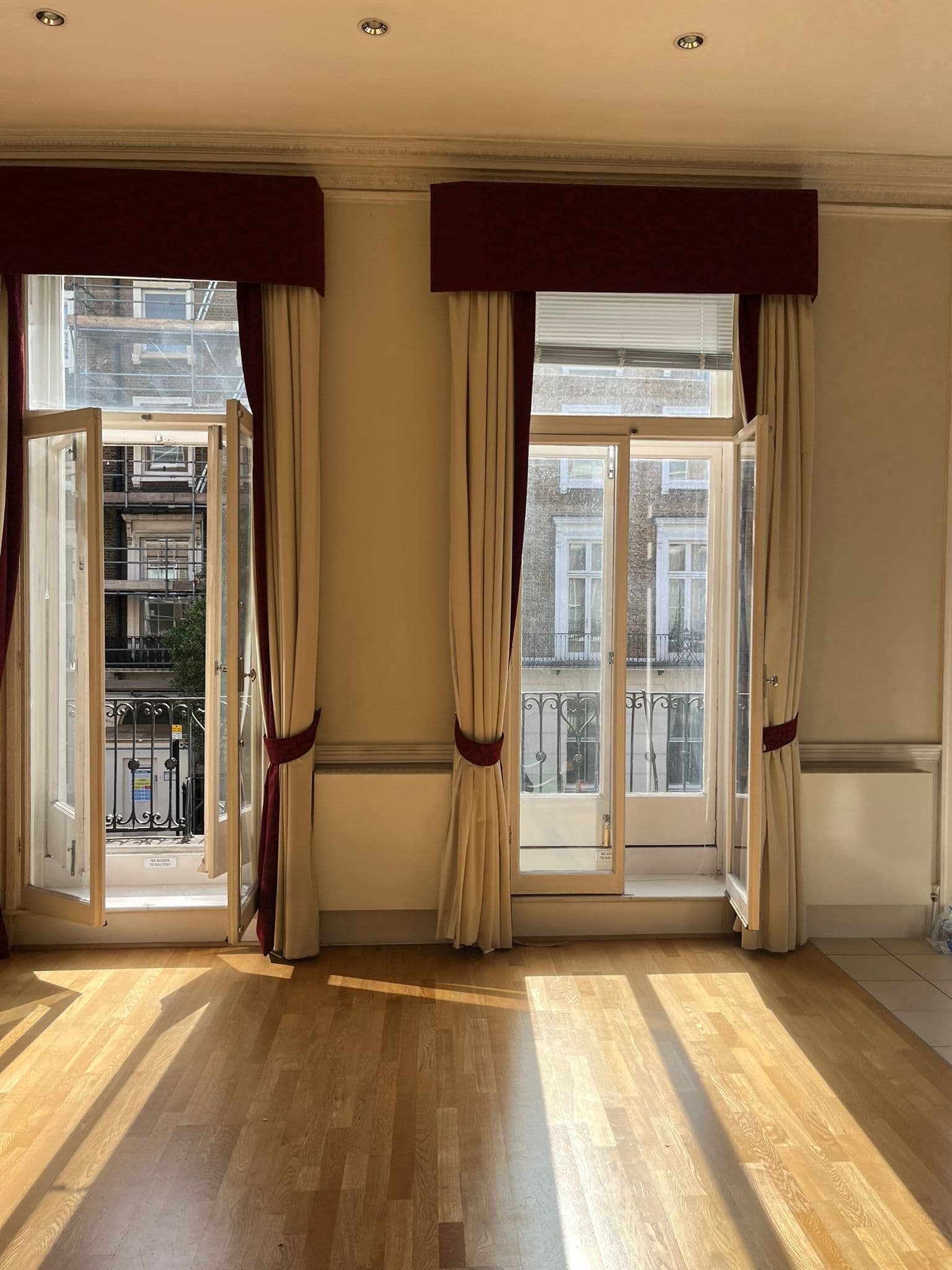 Elegant period living room with French doors, Juliet balconies and a clean wood floor after an end of tenancy clean