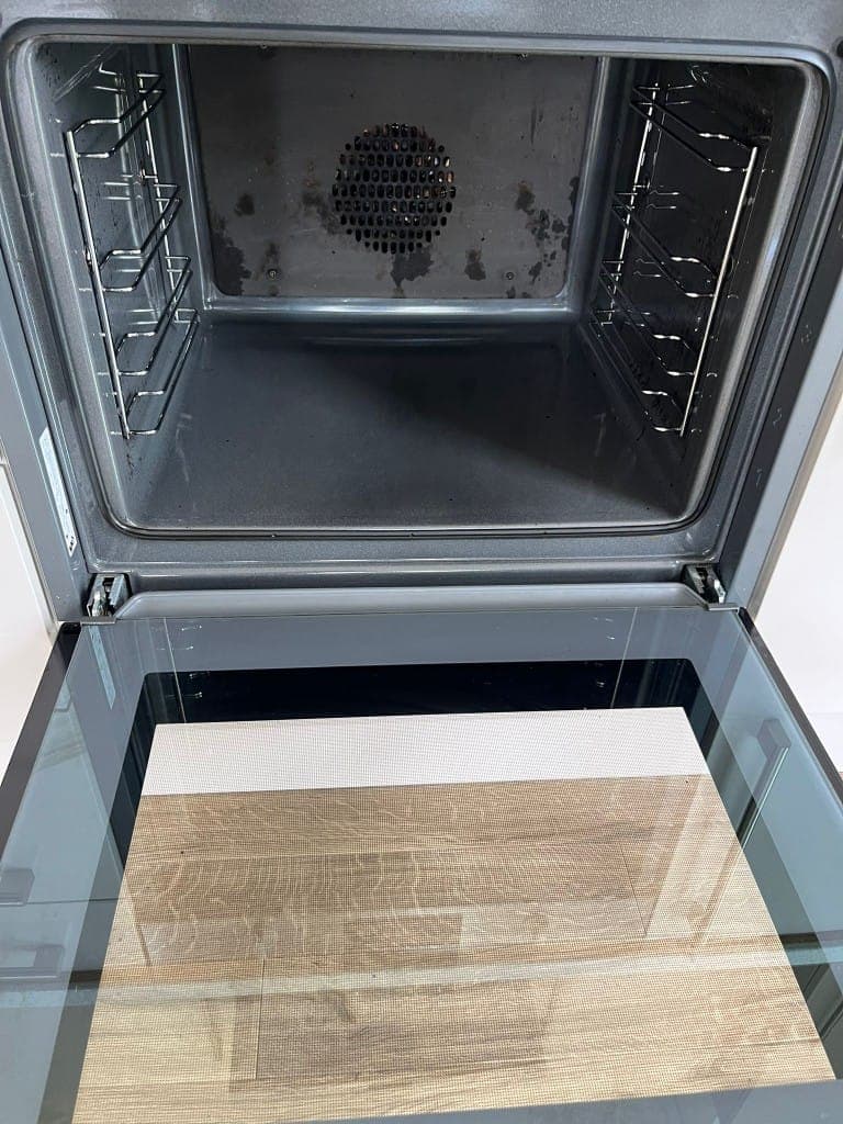 End of tenancy oven cleaning after: spotless oven interior with clean grey enamel, polished racks and streak-free door glass